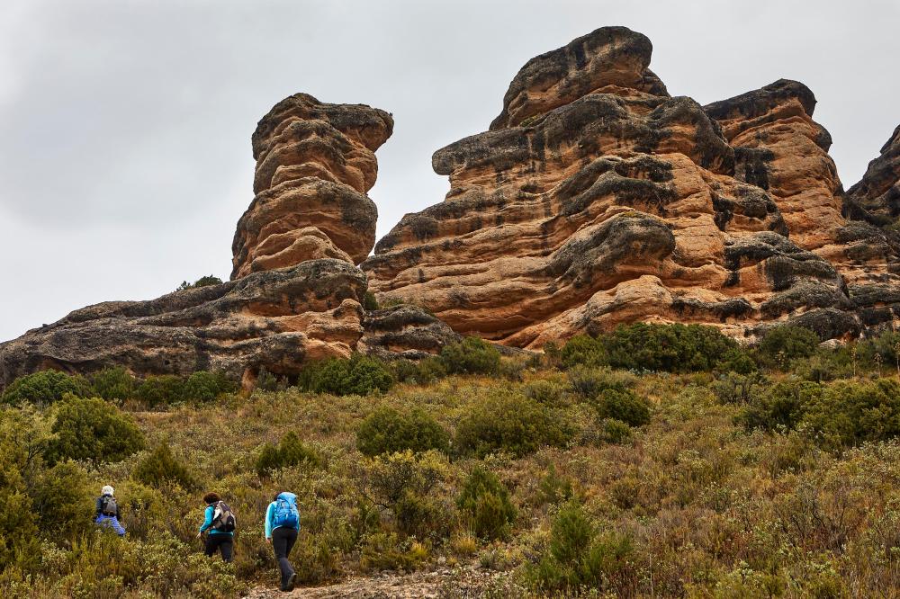 tres senderistas delante de las formaciones de las Rocas de Fitero